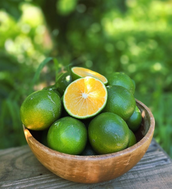 A bowl of green tangerines