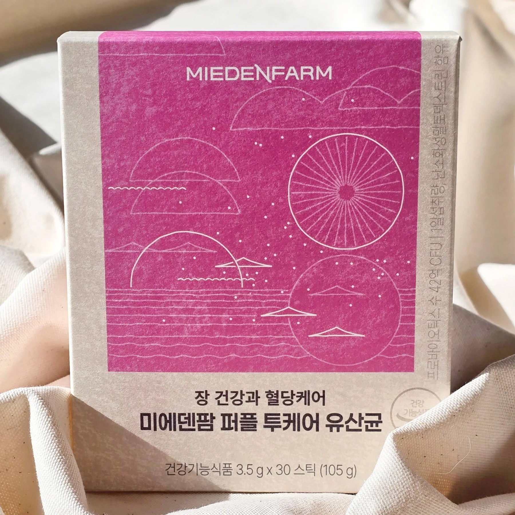 A Purple TwoCare Probiotics box on fabric (photo by MIEDEN FARM)