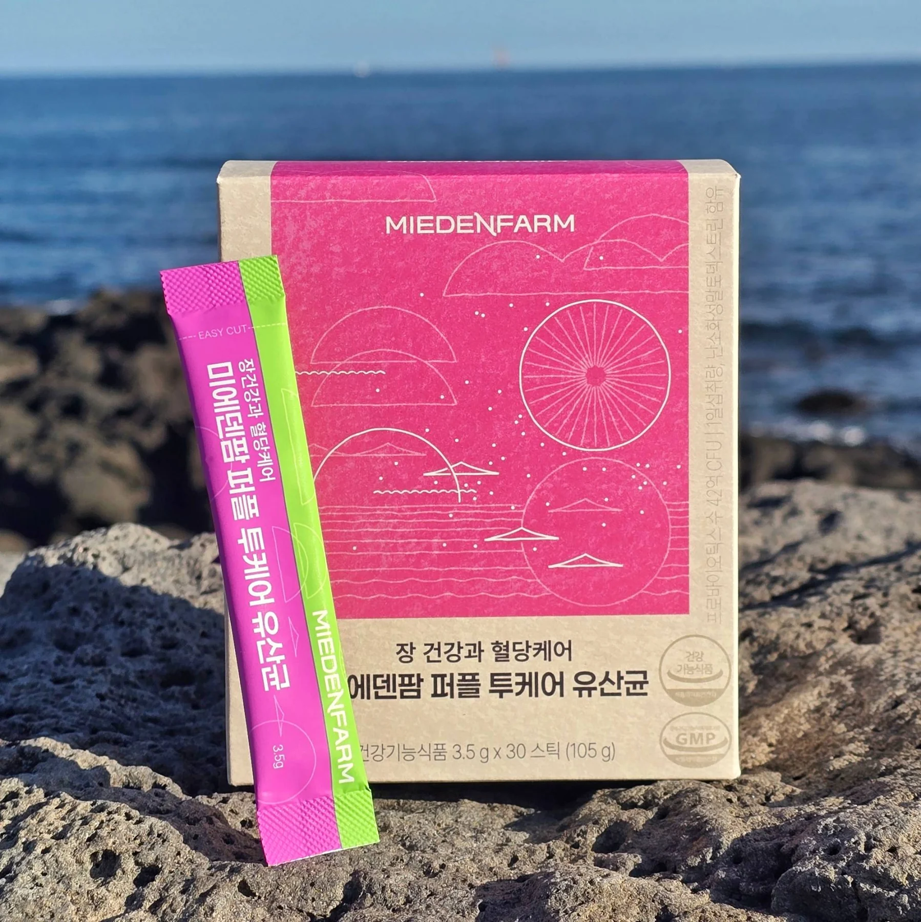 A Purple TwoCare Probiotics box and sticks by the Jeju sea (photo by MIEDEN FARM)