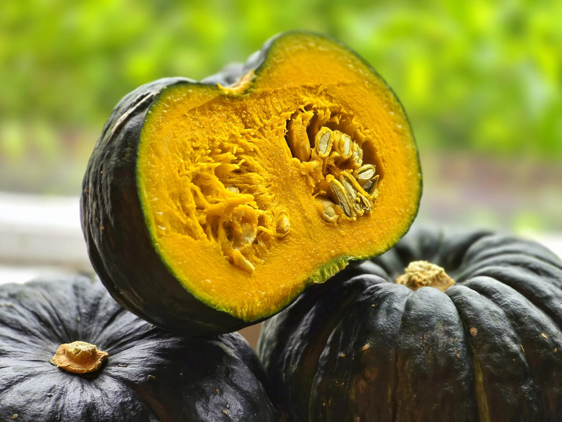 A halved mini kabocha and whole mini kabochas (photo by MIEDEN FARM)